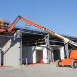 JLG 460SJ boom lift raised on construction site.