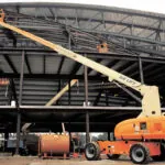 JLG 860SJ boom lift raising workers to top of building.