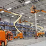 JLG electric articulating boom lifts inside warehouse.