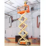 JLG ES2632 raising worker to provide ceiling maintenance.