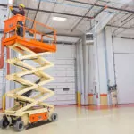 JLG ES3246 electric scissor lift extended in warehouse.