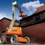 Worker using JLG 340AJ Articulating Boom Lift at construction site.