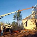 JLG T500J extended boom lift at building construction site.