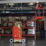 JLG 26E toucan mast boom lift extended in warehouse.