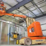 JLG 32E toucan mast boom lift extended indoors.