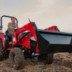 Mahindra 1626 Compact Utility Tractor driving on dirt.
