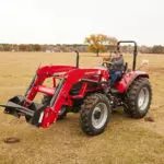 Mahindra 6075 tractor driving in cattle field.