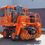 Rail King RK330 G6 mobile railcar mover in concrete lot outside a building.