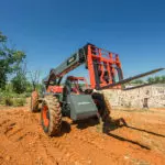 Skyjack SJ843 TH telehandler driving on dirt.