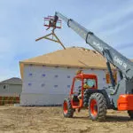 Skyjack SJ843 TH telehandler raising building materials at jobsite.
