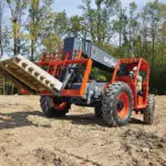 Skyjack SJ843 TH Telehandler on dirt transporting pallet of materials.