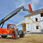 Skyjack SJ843 TH Telehandler transporting building materials on construction site.
