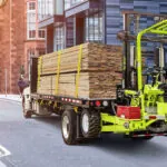 Donkey Container Handler forklift mounted to the back of a lumber truck.