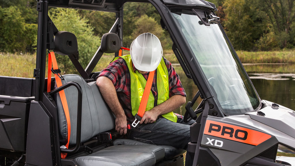 Polaris Commercial PRO XD Full-Size Diesel Utility Vehicle operator buckling up.