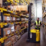 Combilift Combi-CS Counterbalance Stacker Lift Truck mast up carrying material in warehouse.