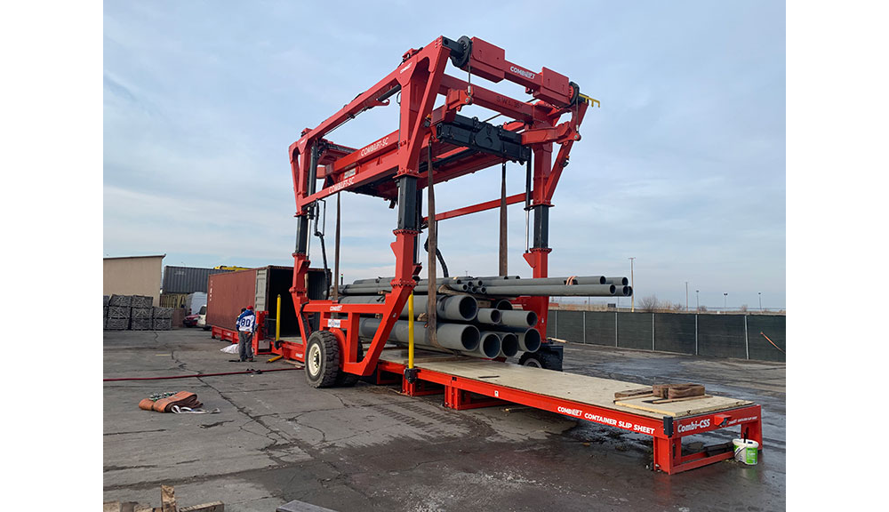 Combilift Combi-CSS container slip sheet, pipes, and toplift straddle carrier.