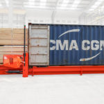 Combilift Combi-CSS container slip sheet with lumber and container side view.