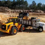 JCB 437 Wheel Loader construction and agriculture truck dumping materials into dump truck.