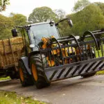 JCB TM-320 articulated telescopic handler with trailer of hay.