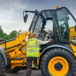 climbing into a JCB TM-320 articulated telescopic handler.