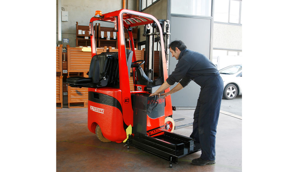Technician repairing Mariotti MYCROS AC RWD 10C Forklift in shop.