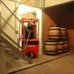 Mariotti Mycros AC forklift driving through a doorway in a winery.