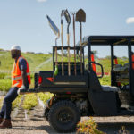 Pro XD Mid-Size Gas Crew Utility Vehicle by Polaris Commercial with man sitting on bed.