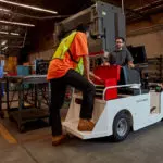 Taylor-Dunn SS-546 Personnel Carrier Utility Vehicle and operator using tool box in workshop.