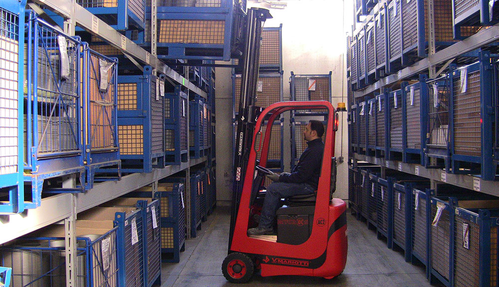 Mariotti MYCROS AC RWD 10C Forklift grabbing pallet in warehouse.
