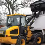 JCB 407 Wheel Loader dumping dirt into dump truck.