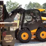 JCB 270W Skid Steer loading materials onto truck trailer.