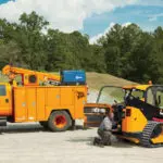 JCB 270T compact track loader and other JCB utility truck on gravel road.