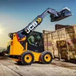 JCB 3TS-8W dumping stones and materials into dumpster.