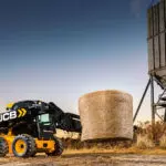 JCB 3TS-8W transporting hay bale.