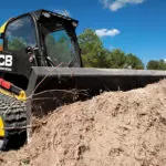 JCB 270T compact track loader pushing dirt with bucket attachment.