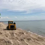 JCB 270T compact track loader driving on sand.