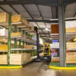 Combilift COMBI-MR4 multi-directional forklift reaching to grab lumber materials.