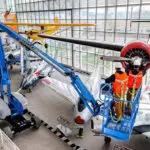 Genie Z-60 DC Articulating Boom Lift lifting technicians to repair hanging aircraft.