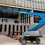 Genie S-80 J telescopic boom lift in action at a construction site.