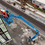 Genie S-80 J telescopic boom lift raising construction workers.