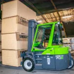Combilift Combi-CB15-5E electric forklift lifting wide pallets in warehouse.