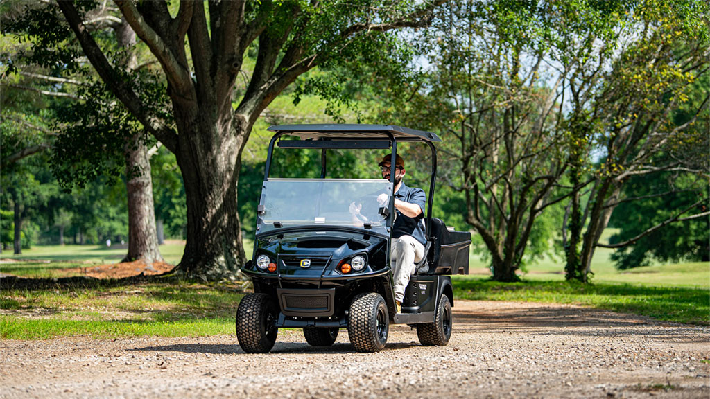 Cushman Hauler 800 utility vehicle driving on gravel path.