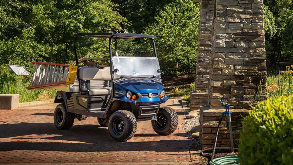 Cushman Hauler Pro-X utility vehicle with ladder on pathway.