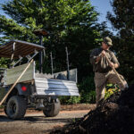 Main doing maintenance with tools out of Cushman Hauler Pro-X utility vehicle cargo bed.