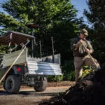 Main doing maintenance with tools out of Cushman Hauler Pro-X utility vehicle cargo bed.