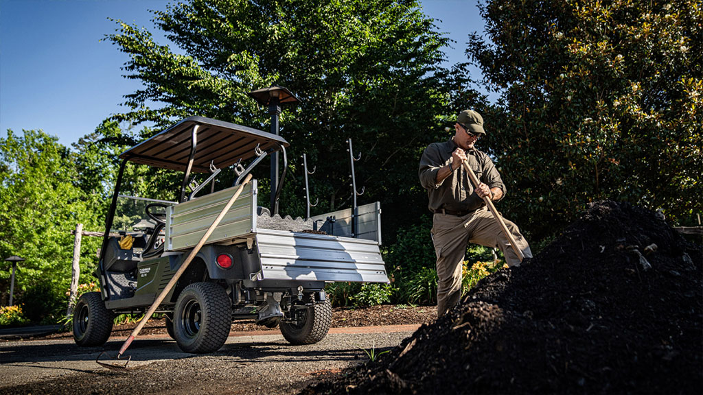 Main doing maintenance with tools out of Cushman Hauler Pro-X utility vehicle cargo bed.
