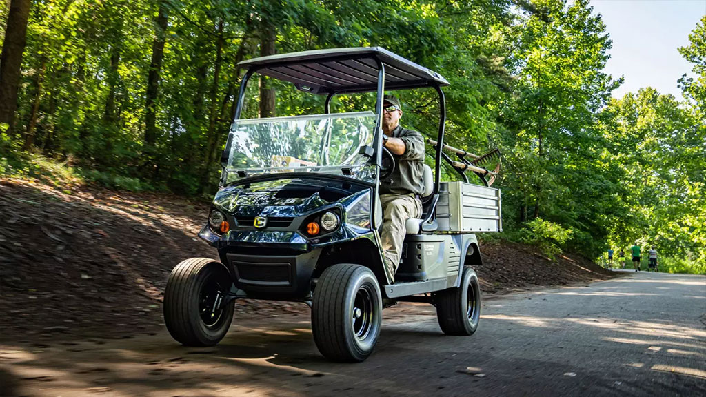 Cushman Hauler Pro-X utility vehicle driving down road.