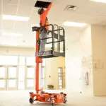 JLG 830P low-level access lift raising a worker to a ceiling.