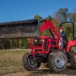 Mahindra 5145 4WD Tractor raising bucket attachment in field.