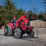 Mahindra 5145 4WD Tractor dumping gravel out of bucket loader attchment.